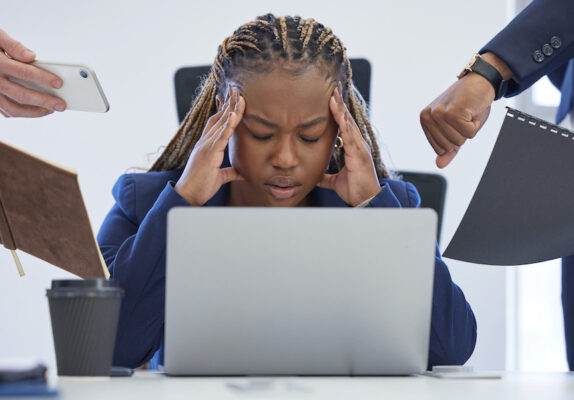 Stressed woman overwhelmed by work demands.